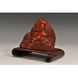 A Chinese red cinnabar lacquer Buddha, seated in contemplation, 6cm high, hardwood stand, c.