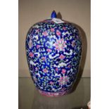 A Chinese ovoid jar and cover, brightly painted in polychrome with flowers and scrolling leaves,