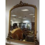 A large Victorian gilt framed arched over mantel mirror, 150cm high x 130cm wide.