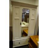 An early 20th century white painted wardrobe, outswept cornice, central mirrored door,