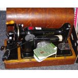 A cased Singer hand powered sewing machine