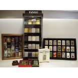 A Zippo POS freestanding display case; 63 Zippo Lighters including Jagermeister, 1935 Varga Girl,