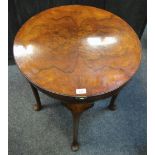 An early 20th century card table burr walnut quarter veneered circular rotating top opening to