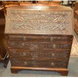 A George III oak bureau, later carved,