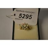 A nine stone opal floral cluster ring, central larger round cabochon opal,