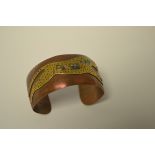A copper open bangle set with brass and abalone leaping leopard