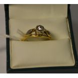 An 18ct gold and platinum solitaire diamond illusion set ring, diamond chips to shoulders,