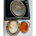 A silver and marcasite pendant; a silver and composite amber ring;
