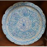 A Persian tin glazed earthenware shaped circular dish,