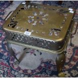 A substantial brass fireside trivet, pierced throughout with geometric motifs,