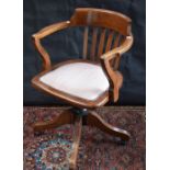 An early-mid 20th century oak swivel desk chair, curved cresting rail, straightened lath back,