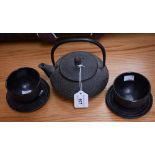 A Canadian iron tea kettle and two tea bowls and saucers,