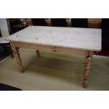 A pine kitchen/dining table, rounded rectangular top above a single frieze drawer, turned legs,