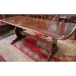 An Ercol elm trestle type dining table, rounded rectangular top, shaped vasular end supports,