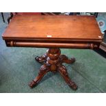 A 19th century mahogany tea table, hinged rounded rectangular top, substantial turned column,