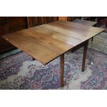 An early 20th century oak gateleg dining table, rectangular top with fall leaves,