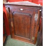 A George III oak wall hanging corner cupboard,