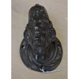 A Renaissance style bronze architectural boss, cast as the head of a grotesque Venetian, 12cm high,