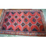 A large hand knotted rug, geometric design on claret ground,