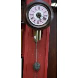 A 19th century circular 'postman's' alarm wall clock, with pendulum and weights, c.