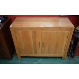 A contemporary oak sideboard, rectangular top above a pair of cupboard doors enclosing a shelf, 112.