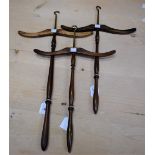A set of three Edwardian gentleman's mahogany hangers, brass hooks, arched arms, turned poles,