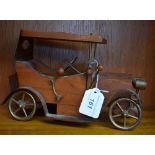 A teak model of a vintage car,