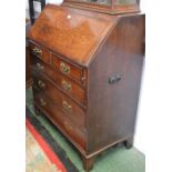 A 19th century oak bureau, of large proportions, fall front enclosing a small central door,