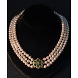 String of Pearls A three strand cultured pearl necklace,