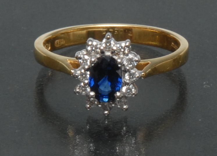 A diamond and sapphire cluster ring, central oval mid blue sapphire approx 0.