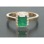 An emerald and diamond ring, central rectangular emerald approx 1.