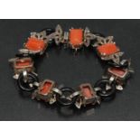 An Art Deco style diamond, coral and black onyx articulated fancy link multi layer panel bracelet,