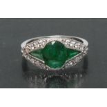 An emerald and diamond ring, central oval deep green emerald, approx 1.