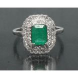 An emerald and diamond cluster ring, central rectangular emerald cut emeralds approx 0.