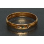 An emerald and diamond set wedding band, central round emerald approx 0.