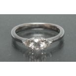 A diamond trilogy ring, central round brilliant cut diamond approx 0.