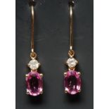 A pair of pink sapphire and diamond drop earrings, each with a single oval pink sapphire approx 0.