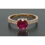 A ruby and diamond ring, central deep red round cut ruby, approx 1.