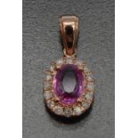 A pink sapphire and diamond pendant, central ovar pink sapphire approx 0.