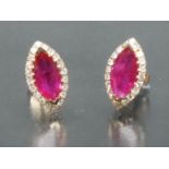 A pair of ruby and diamond earrings, each with a central pinky red marquise cut ruby, approx 1.
