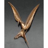 A stylized bird brooch, three dimensional cast V shaped body, out swept tapering wings and tail,