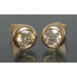 A pair of diamond stud earrings, each collar set with a single round brilliant cut diamond,