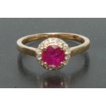 A ruby and diamond ring, central round cut deep red ruby approx 0.