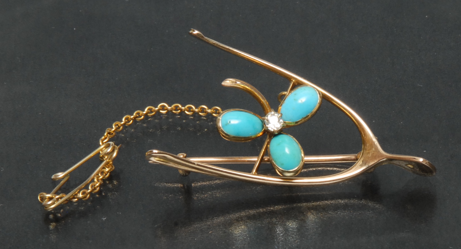 An Edwardian 15ct gold floral wishbone brooch,