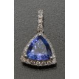 A tanzanite and diamond pendant, inset with a central trilliant cut purplish blue tanzanite,
