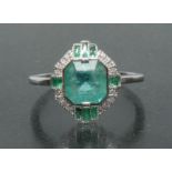 An Art Deco style emerald and diamond cluster ring, central emerald cut pale green emerald approx 2.