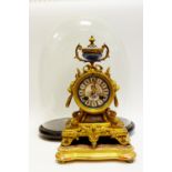 A 19th century French gilt metal mantel clock, with porcelain circular dial with Roman numerals,