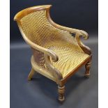 A Regency mahogany bergere elbow chair, curved top rail, outswept arms, scrolling terminals,