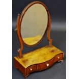 A George III mahogany dressing mirror, oval plate, serpentine base, with three drawers, ogee feet,