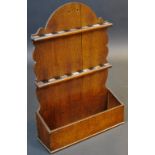 A 19th century oak spoon rack, arched cresting above two rows of apertures, candle well to base,